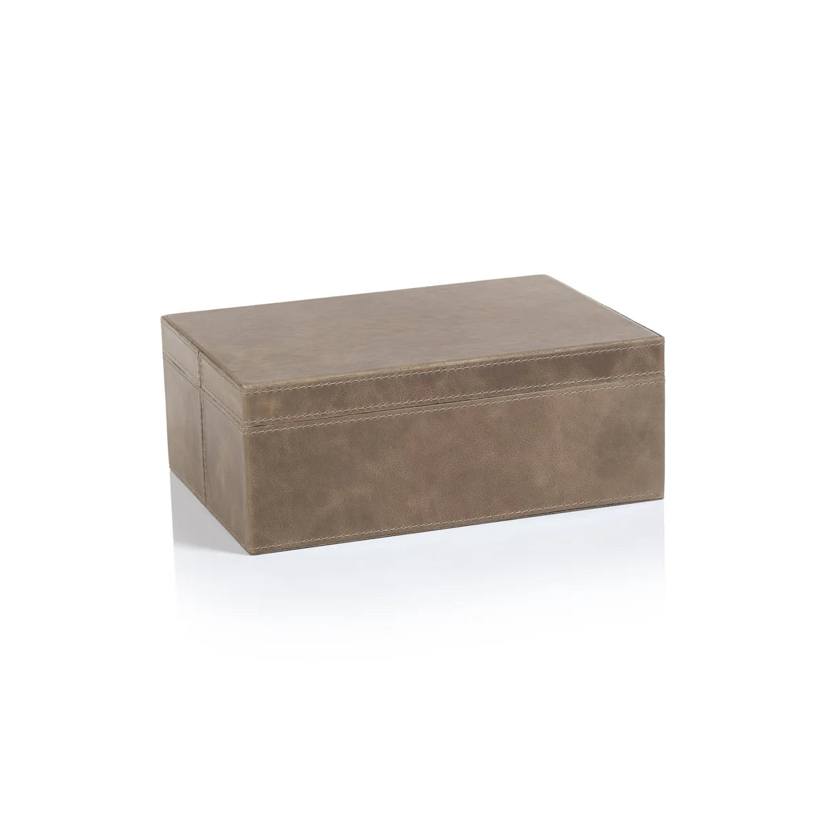 The Mink Leather Box is a small, rectangular brown leather box with visible stitching, closed and placed on a white surface that shows its faint reflection.