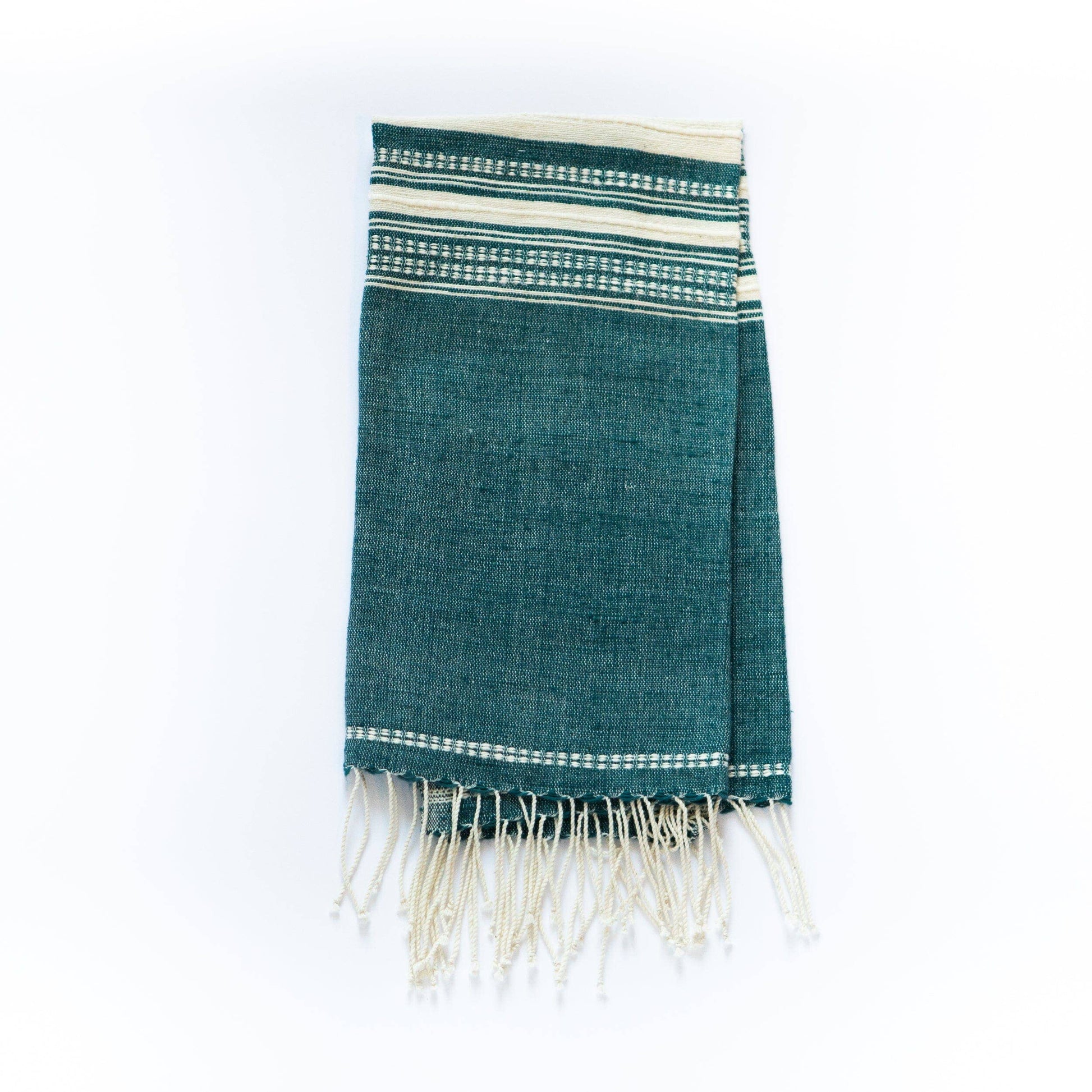 A Handwoven Ethiopian Cotton Hand Towel in teal with white horizontal stripes near one end and fringed edges, shown folded on a white background.