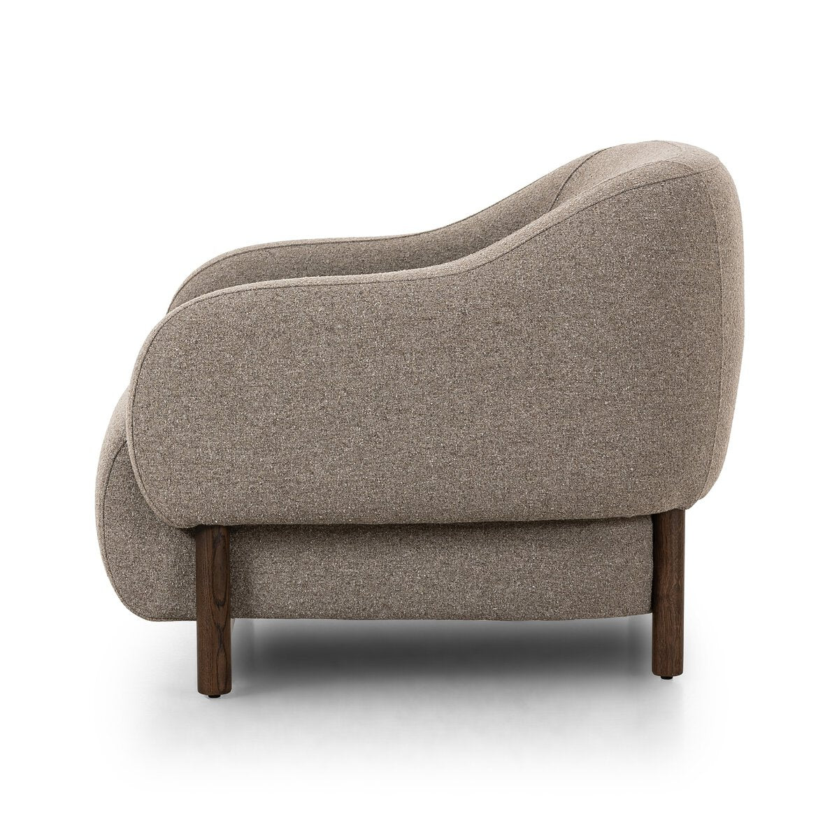 Side view of the Grey Weave Arm Chair with rounded edges, wooden legs, and minimalist design in light grey fabric, set against a white background to highlight its contemporary style and sleek arm chair dimensions.
