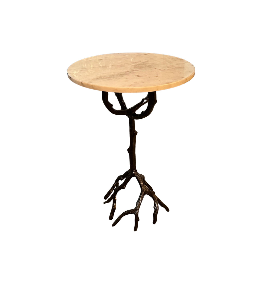The Iron and Marble Side Table features a small round marble top and a vintage iron base resembling tree branches and roots, set against a white background.