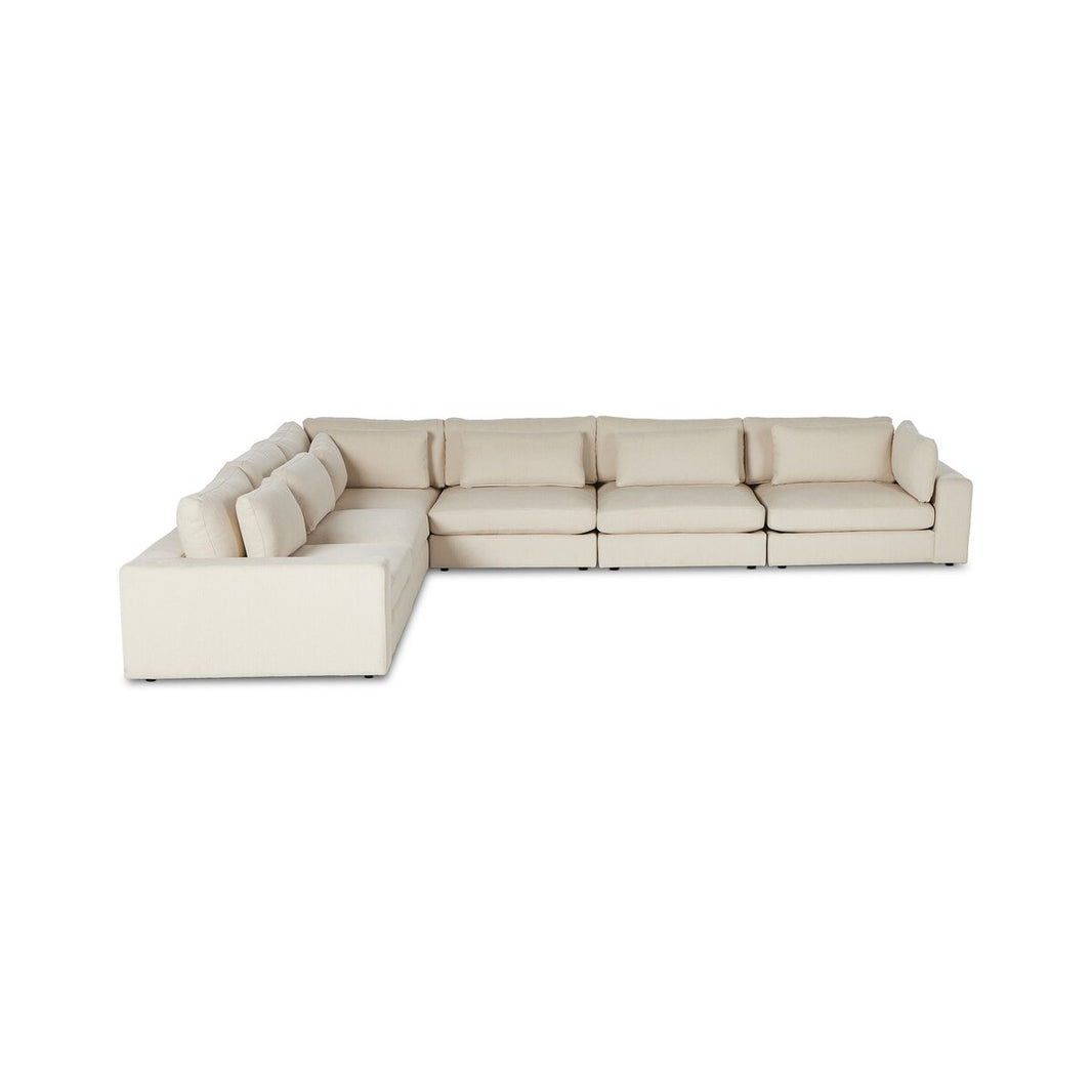 The 6pc Low Modern Sectional is a large, light beige sofa with thick seat and back cushions and low square arms, ideal for living rooms. Upholstered in fabric, it’s pictured against a plain white background.