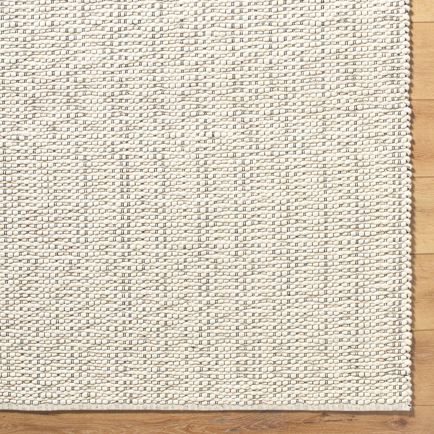 The Bubble Knots Rug - 8'x10', a cream-colored rectangular woven rug with a textured grid-like pattern and small, evenly spaced rows, lies on a wooden floor. Also available in various sizes.
