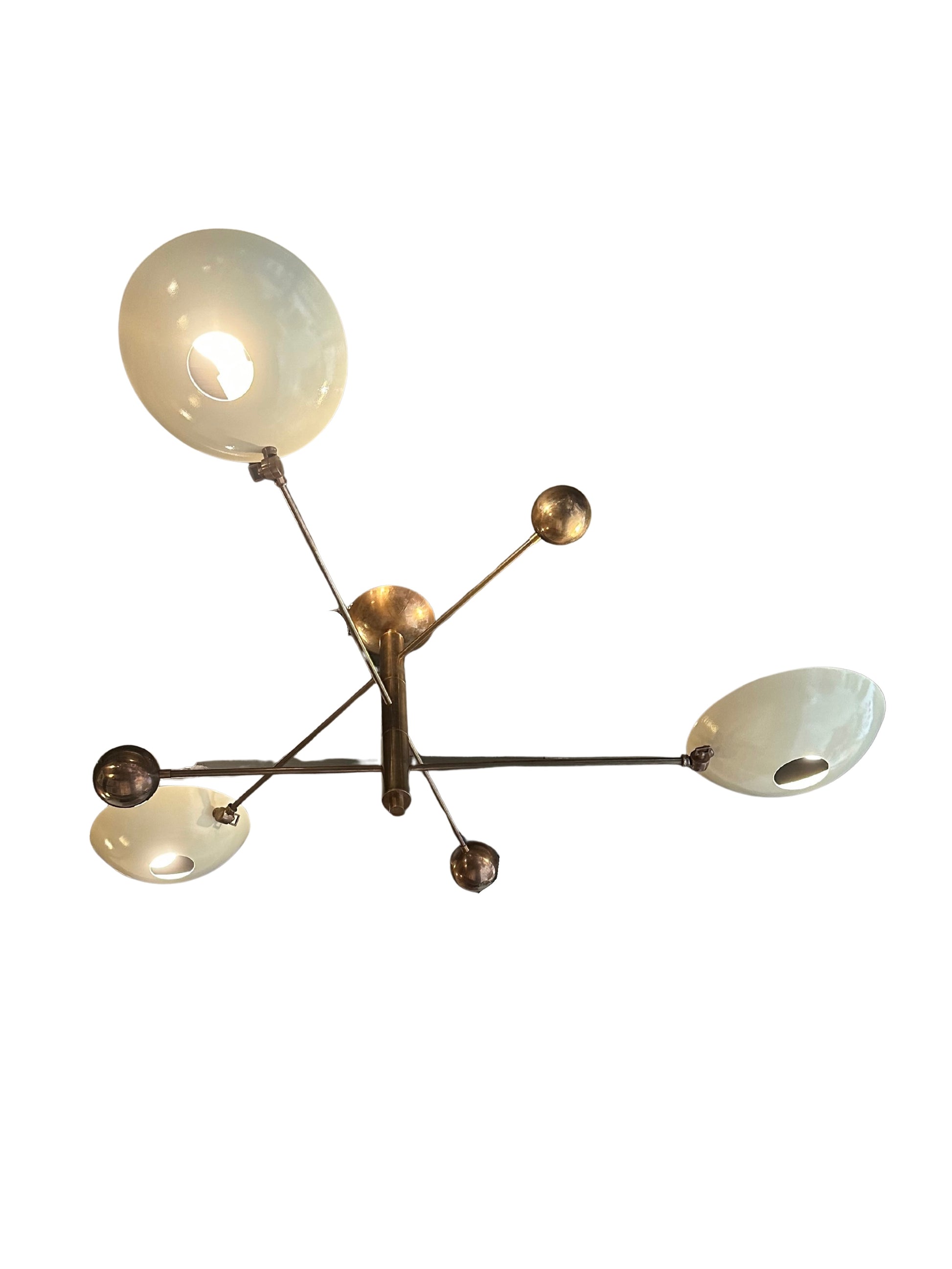 The Mid Century Brass Chandelier features three white bowl-shaped lampshades and multiple brass arms and spheres extending from a central base, creating an elegant, abstract look. Photographed against a white background.