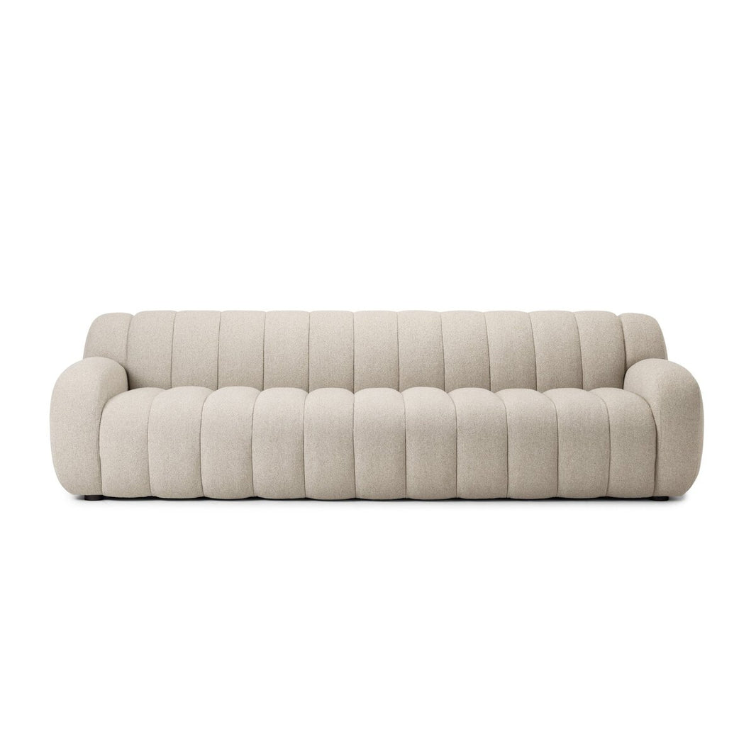 The Plush Channeled Sofa is a modern beige piece with cloud-like, ribbed upholstery, rounded armrests, and wide channeling, shown from the front against a white background.