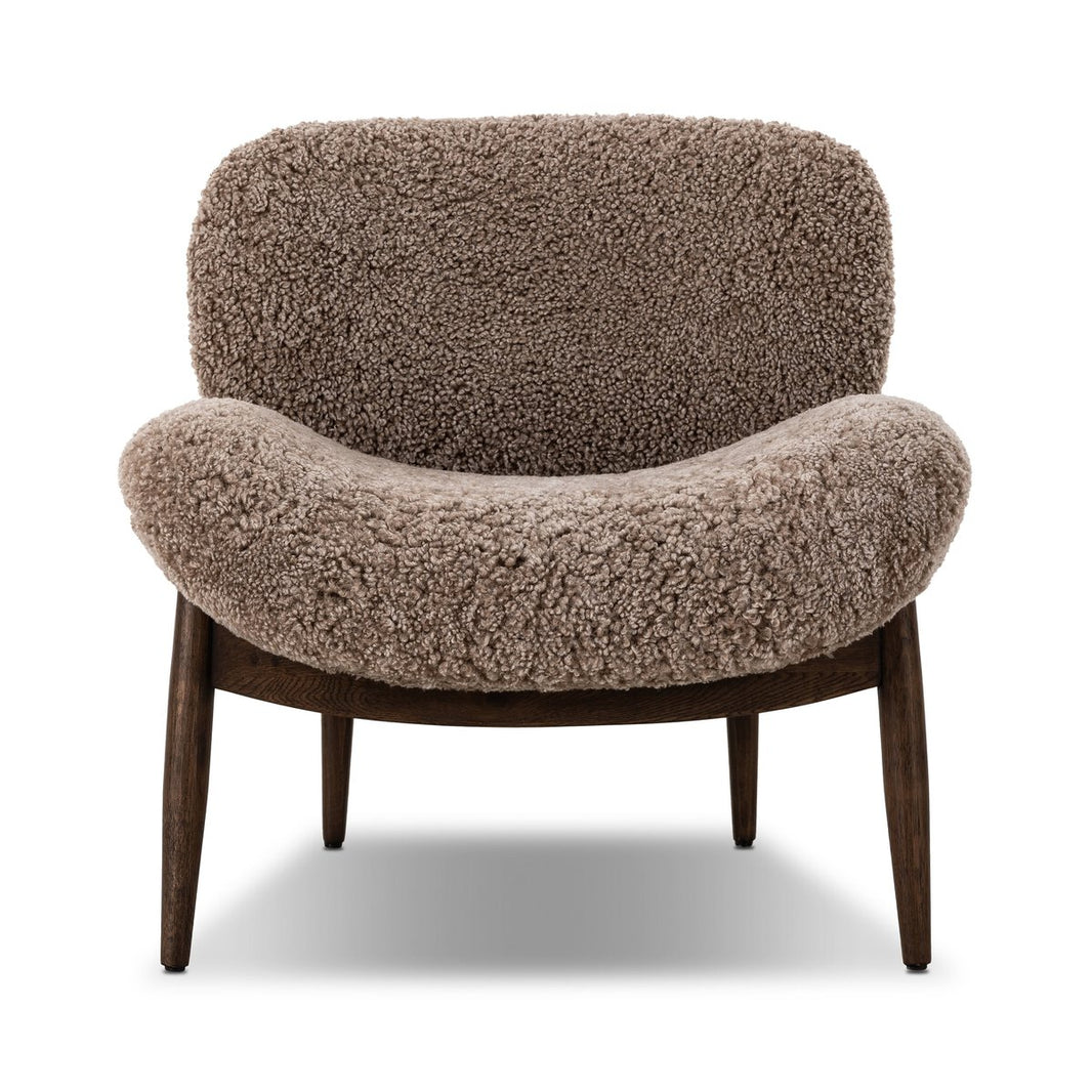 The Shearling Accent Chair features a curved back and seat in textured brown faux shearling, green chenille accents, and four angled dark wooden legs, displayed against a white background.