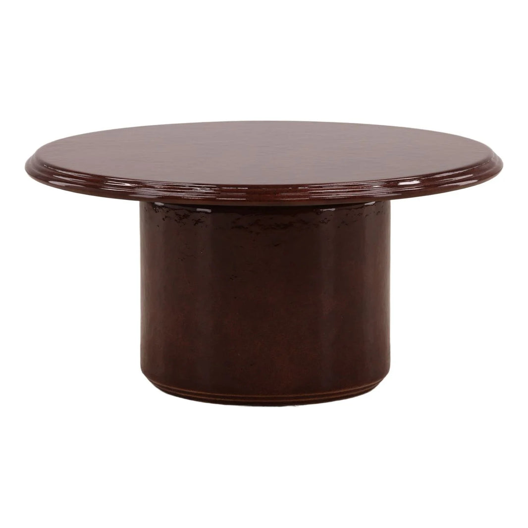 A round Outdoor Red Concrete Coffee Table with a thick, cylindrical base and a smooth, polished surface; perfect as a 31.5 inch table for any space.