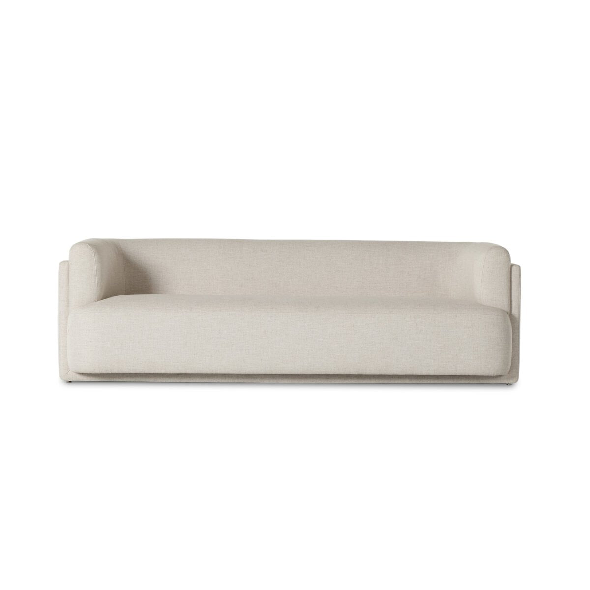 The Exposed Frame Sofa is a modern, minimalist piece with full cream upholstery, a boxy silhouette, low backrest, and subtly curved armrests, displayed on a plain white background.