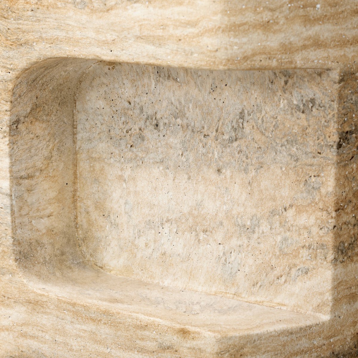 A close-up of the Textured Concrete End Table displays its beige, textured surface with a travertine finish, showcasing natural color variations and detailed craftsmanship.