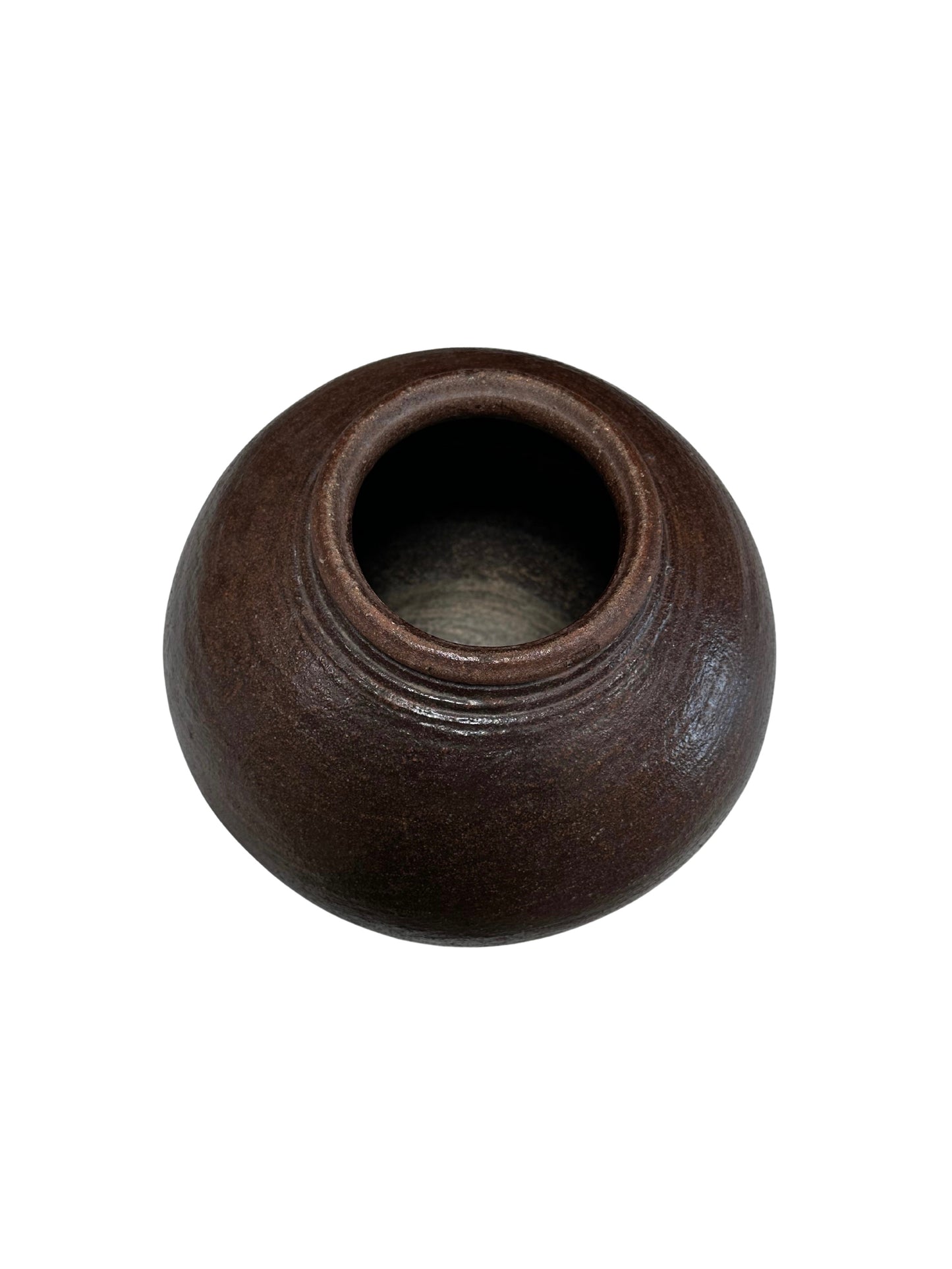 The Rustic Ceramic Vessel is round and dark brown with a wide opening, viewed from above against a white background. It features a slightly textured, matte surface for a rustic look.