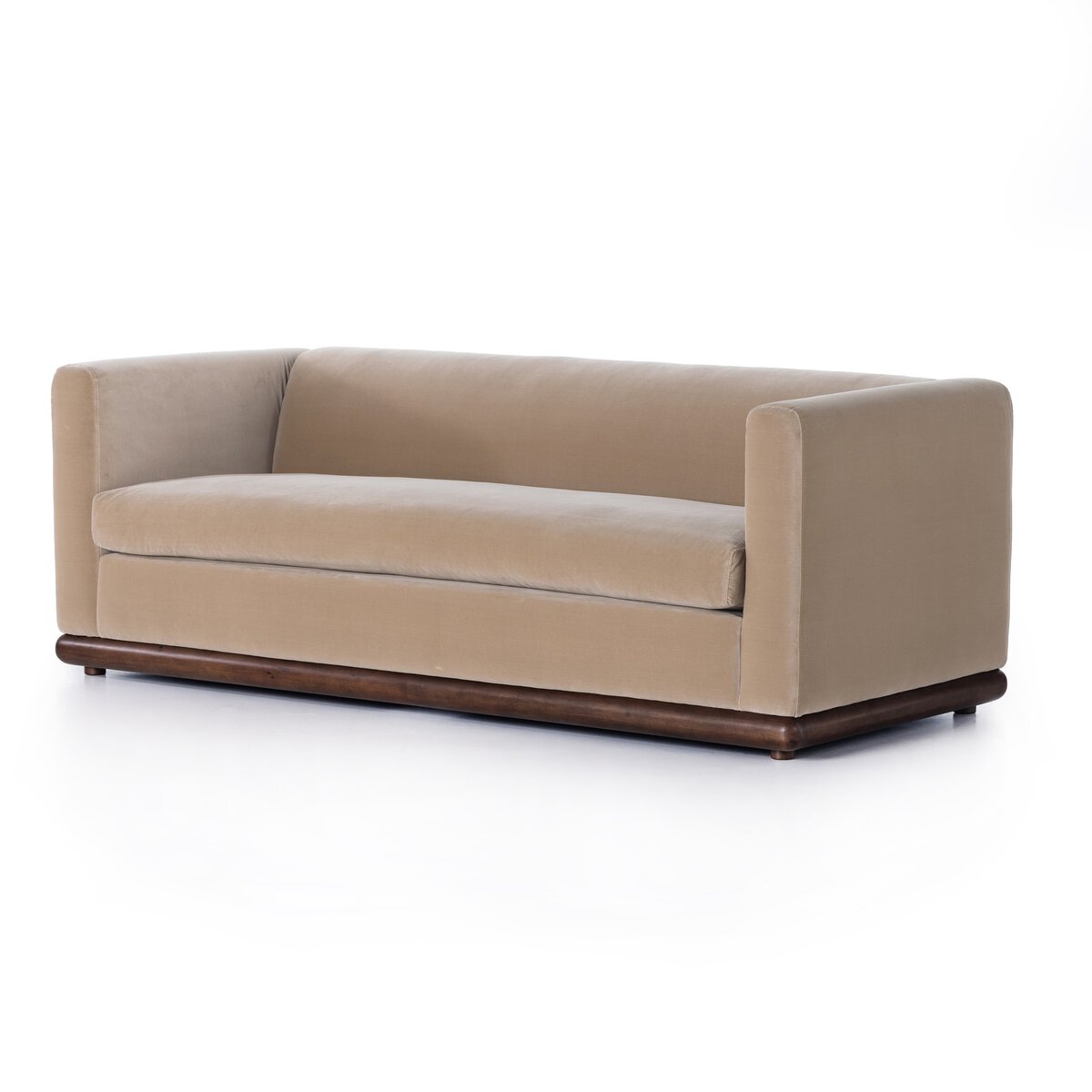 The Deco Sofa features a boxy design with straight arms, a parawood plinth base, and velvety taupe upholstery, shown against a plain white background.
