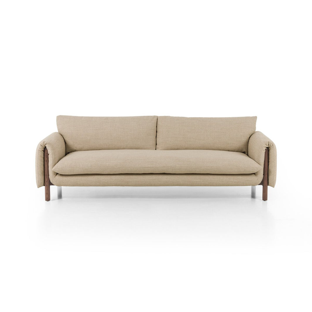 The Linen|Wood Wrap Sofa is a beige, modern three-seater with plush cushions, wide wrap arms, and slim wooden legs, shown against a plain white backdrop.