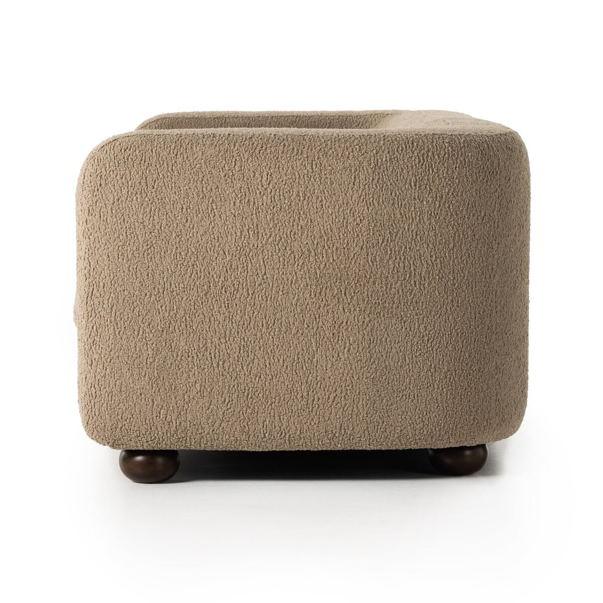 A side view of the Faux Shearling Sofa in light brown camel-textured fabric, featuring rounded edges and dark wooden ball-shaped feet, set against a white background.