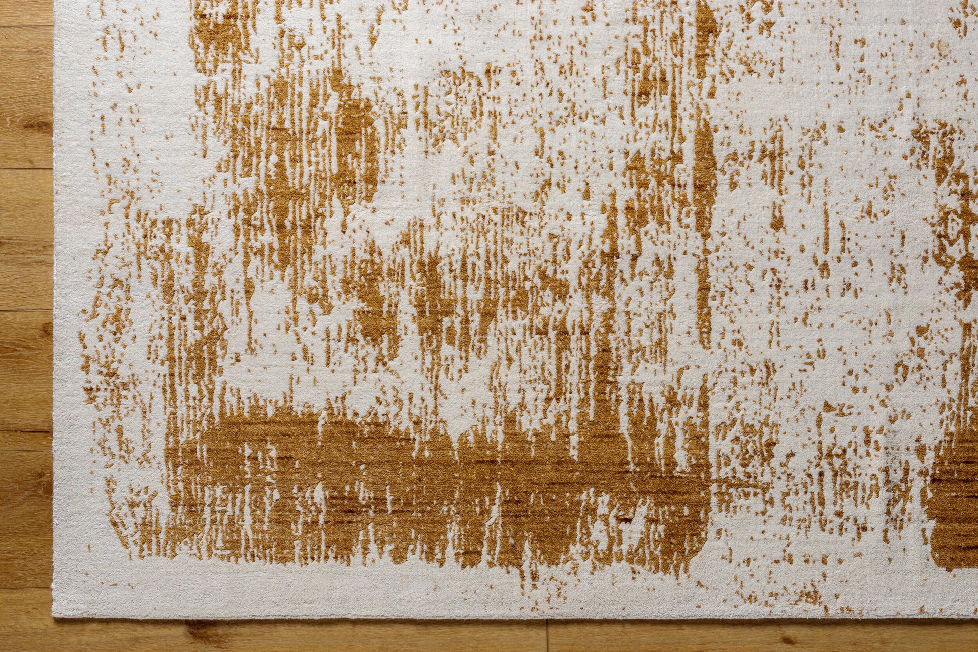 A close-up of the Abstract Color Splash Rug (8x10) on a light wooden floor, featuring irregular, brushstroke-style brown markings on a white background for an artistic, modern look.