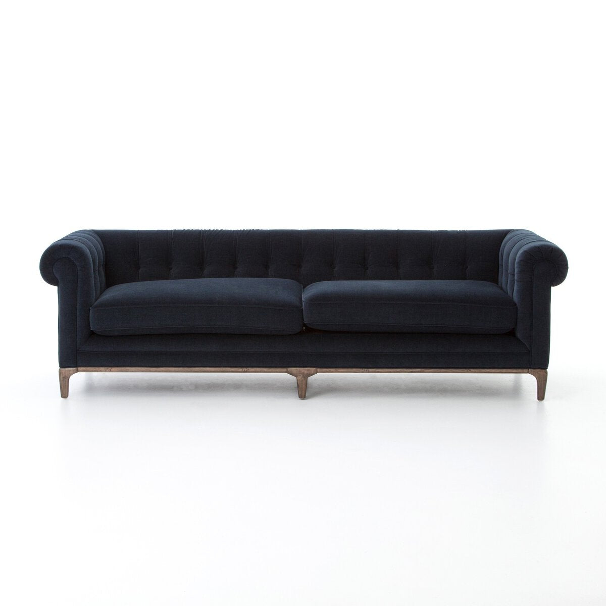 The Chesterfield Navy Sofa features dark navy blue upholstery, tufted detailing, rolled arms, and wooden legs. Set against a white background, its classic design and elegant dimensions are accentuated.