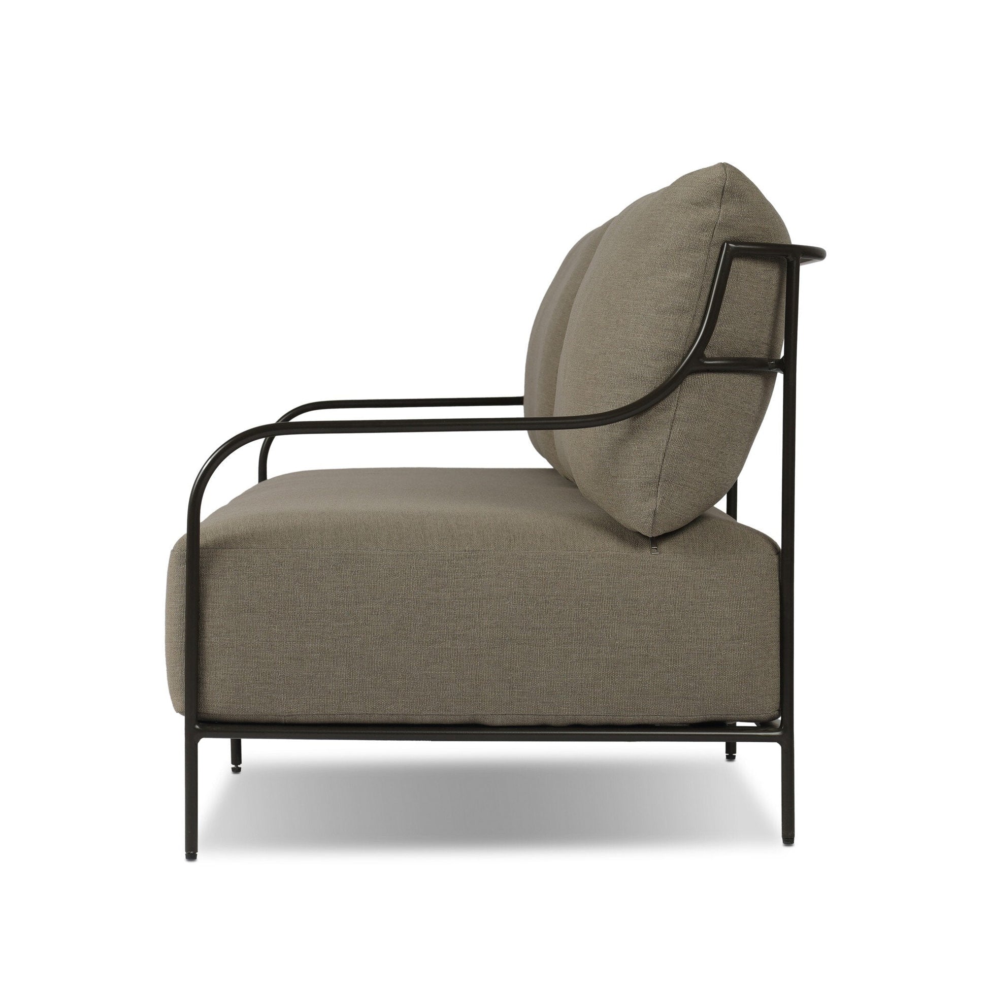 Side view of the Segovia Outdoor Sofa featuring a black metal frame and thick, light brown cushions. Its minimalist design and compact measurements are highlighted against a white background, showcasing its sleek style.