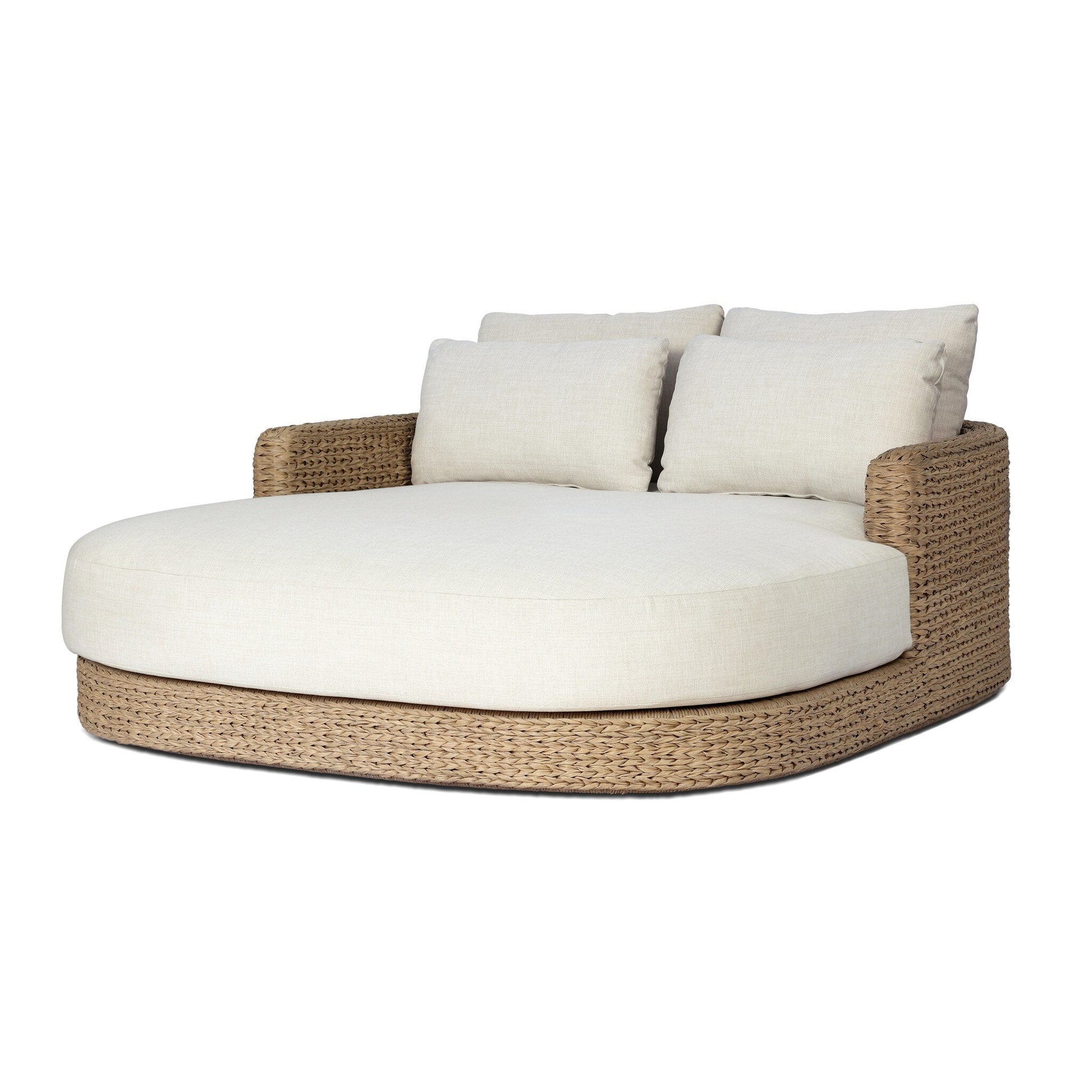 The Chaney Outdoor Double Chaise is a spacious, round daybed with a woven rattan base, cream seat cushion, and two matching back pillows. Measuring about 62"x71" with a 32.75" height, it features short armrests and a relaxed modern style.