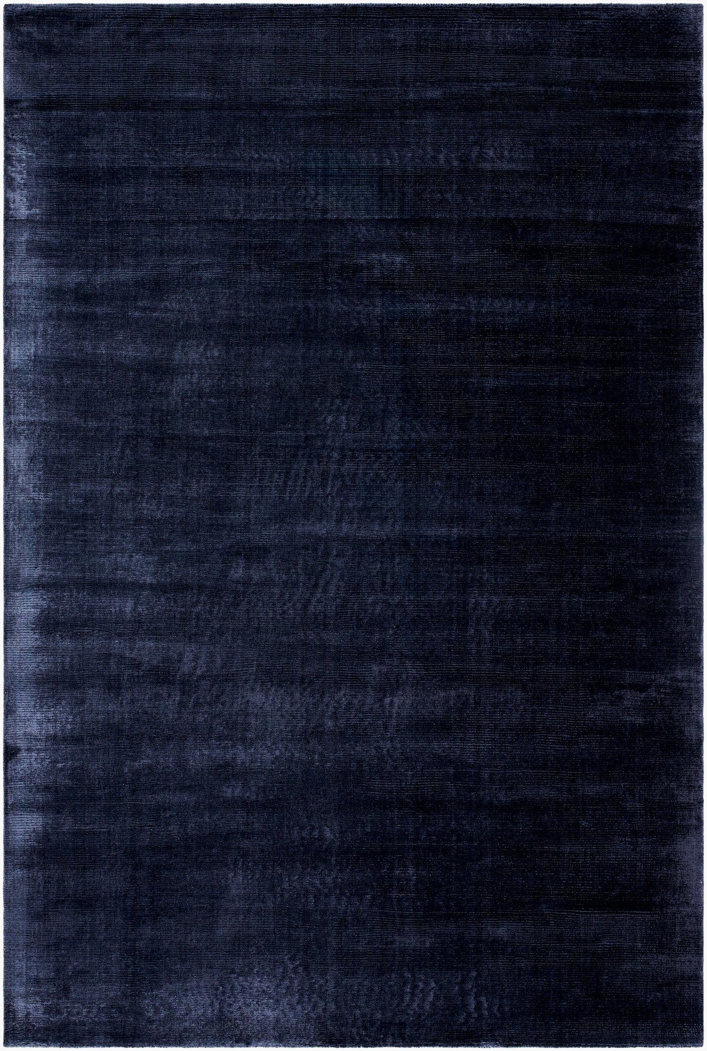 The Striped Cord Rug 8 x 10 features a rectangular, solid dark blue design with a subtle textured pattern and a lighter blue border. Its soft, velvety surface adds depth and richness to any space.