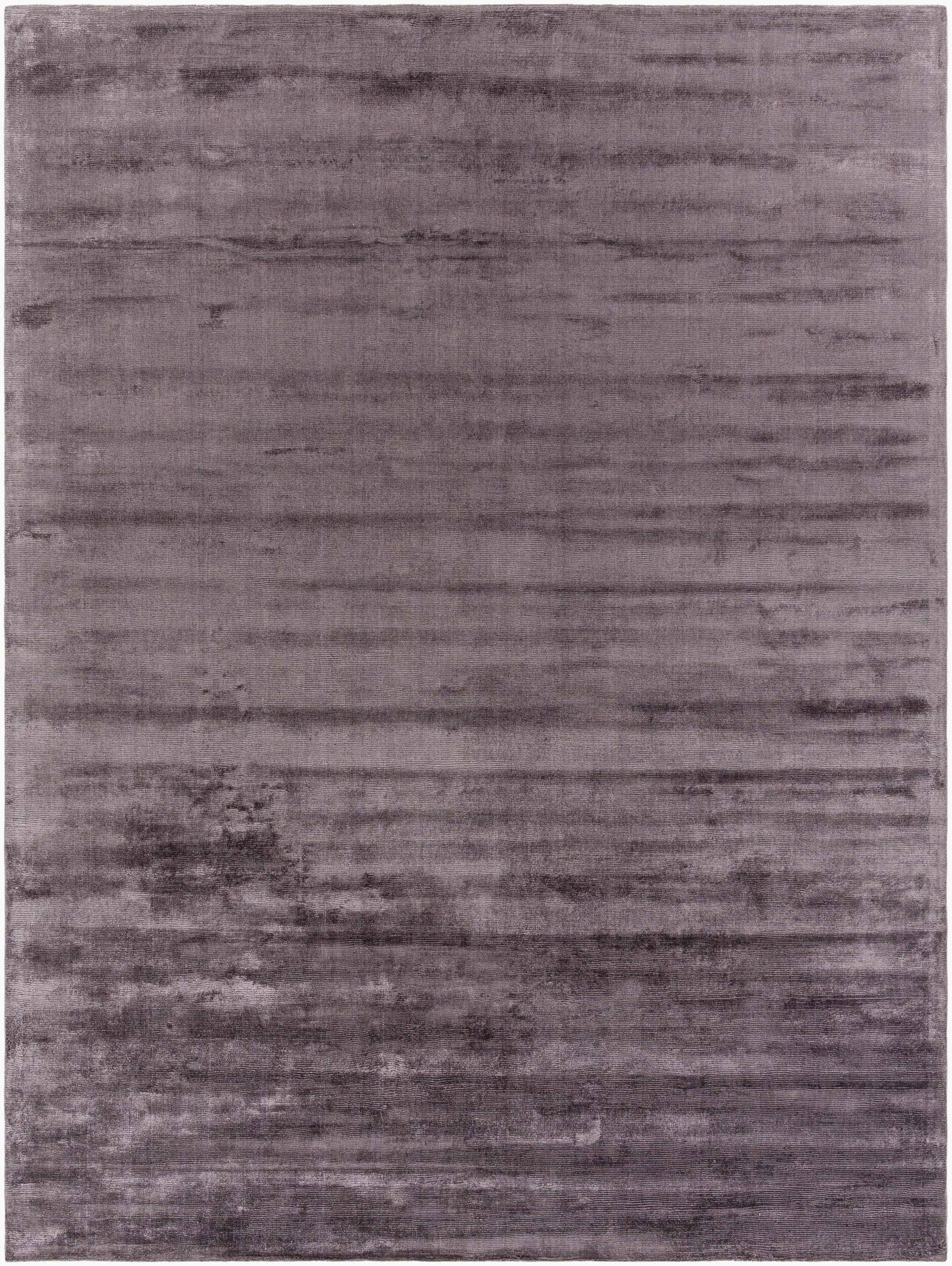 The Striped Cord Rug 8 x 10 has a soft, velvety texture with subtle horizontal stripes, featuring varying shades of purple and lavender in a slightly mottled design.