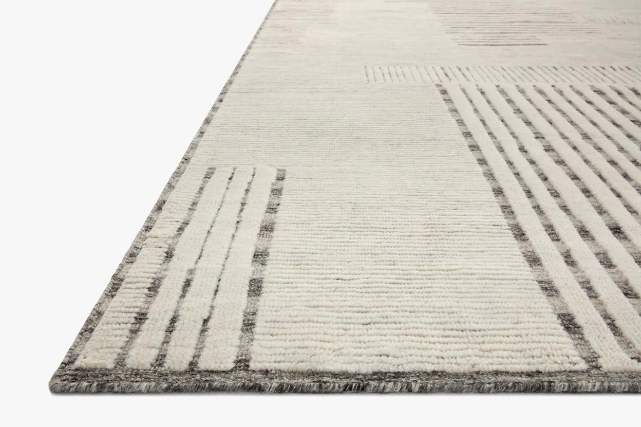 Close-up of the Geometric Striped Textured Wool Rug (8'6x11'6), featuring a rectangular, light-colored surface with grey lines and geometric patterns. Shown in detail on a white background; available in various sizes to fit your space.