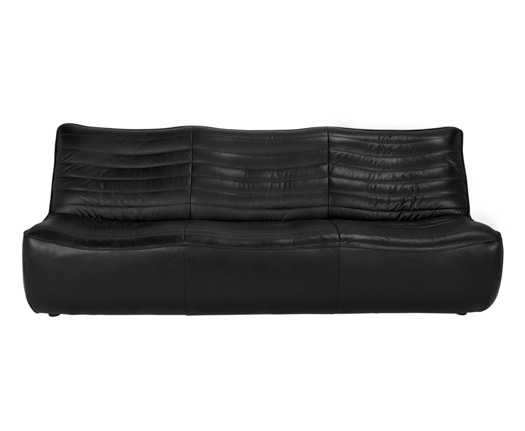 The Leather Low Profile 3 Seater is a modern black full-grain leather sofa with a low backrest, horizontal stitching, and a slightly curved cushioned design, finished with sleek, discreet legs.