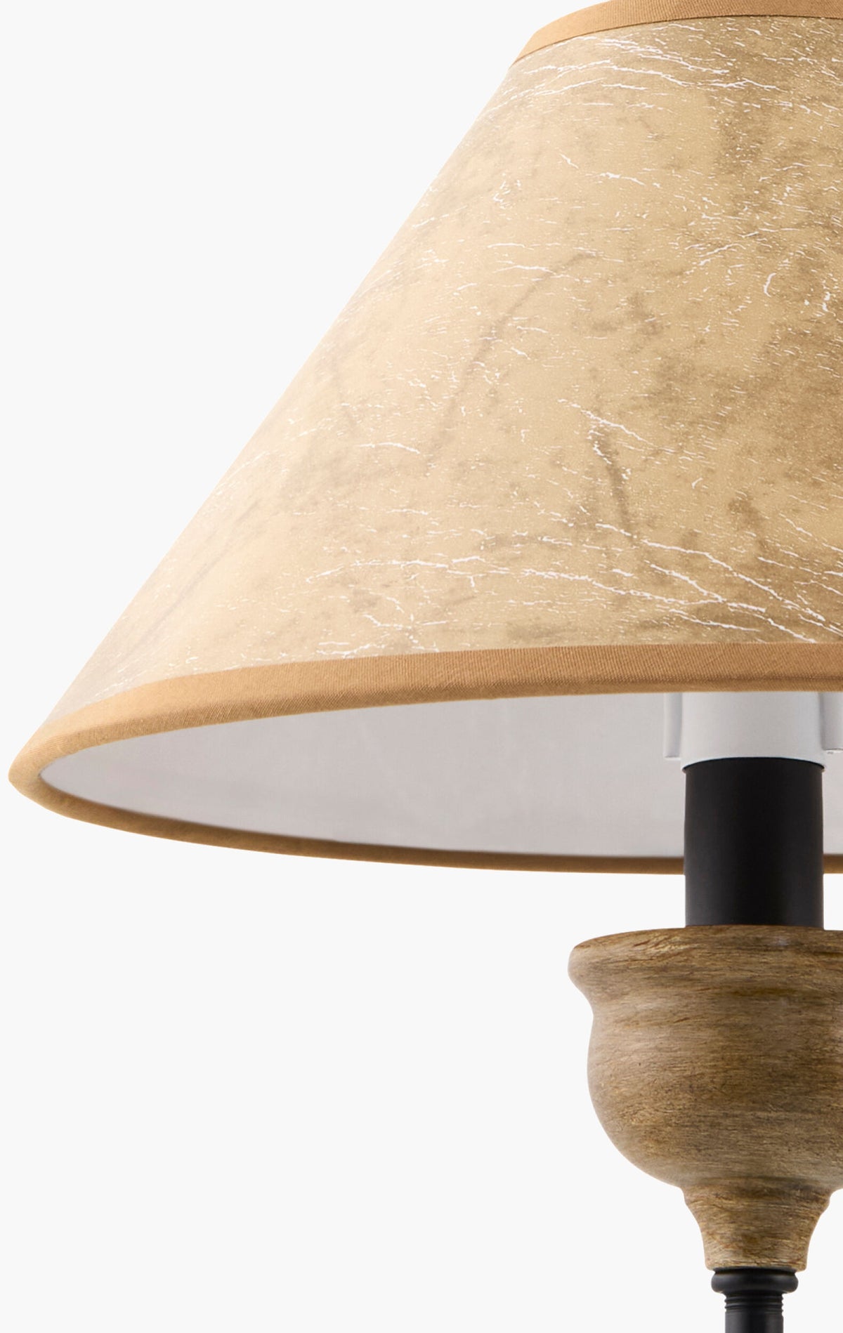 A close-up of an Iron and Leather Chandelier lamp with a textured tan shade and wooden base, resting on a 41 inch square table.