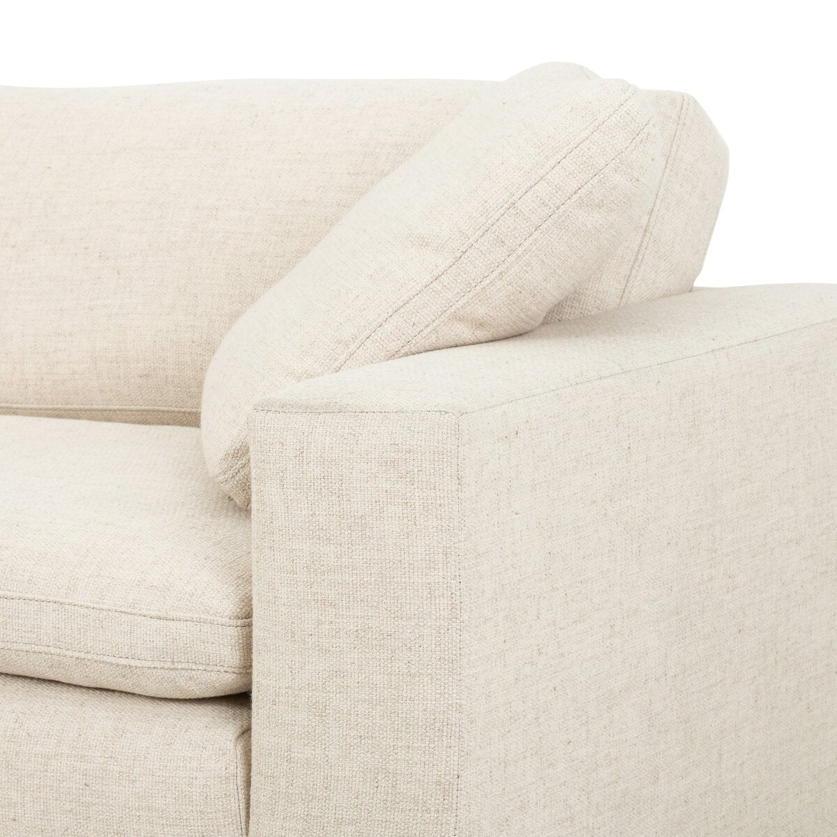A close-up of the Performance Cream Sofa’s armrest and backrest, showcasing its modern, clean lines, loose back cushion, feather filling, and stain-resistant fabric.