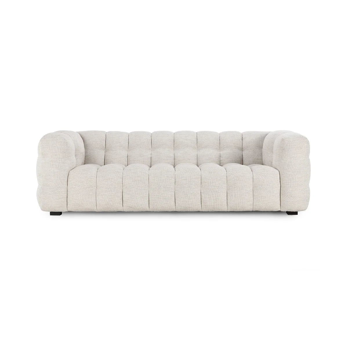 The Upholstered Sofa, shown from the front against a plain white background, has light beige tufted fabric, rounded tuxedo arms, and deep upholstery for a modern look.