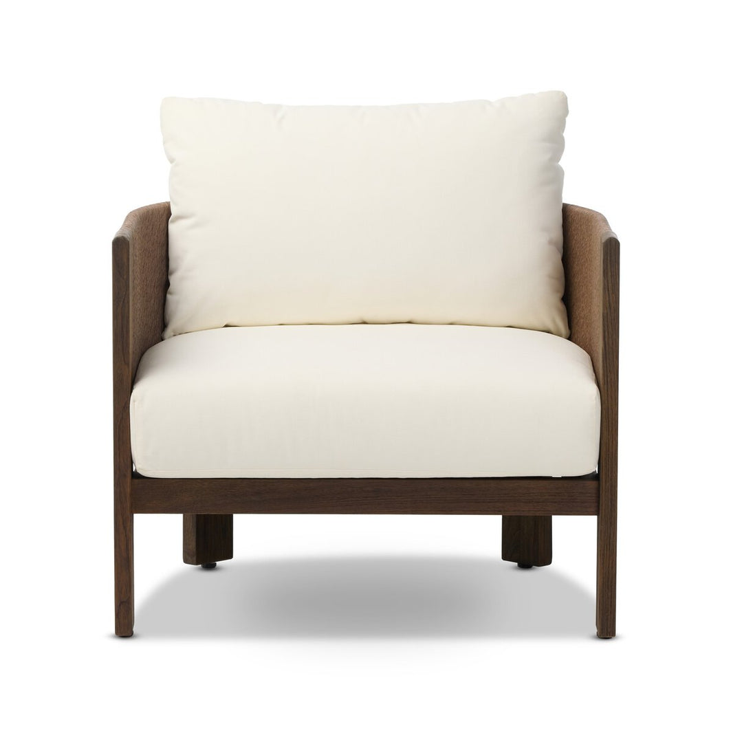 The Woven Outdoor Chair features a modern barrel back, a dark wooden frame, and thick off-white seat and back cushions, shown from the front against a white background.