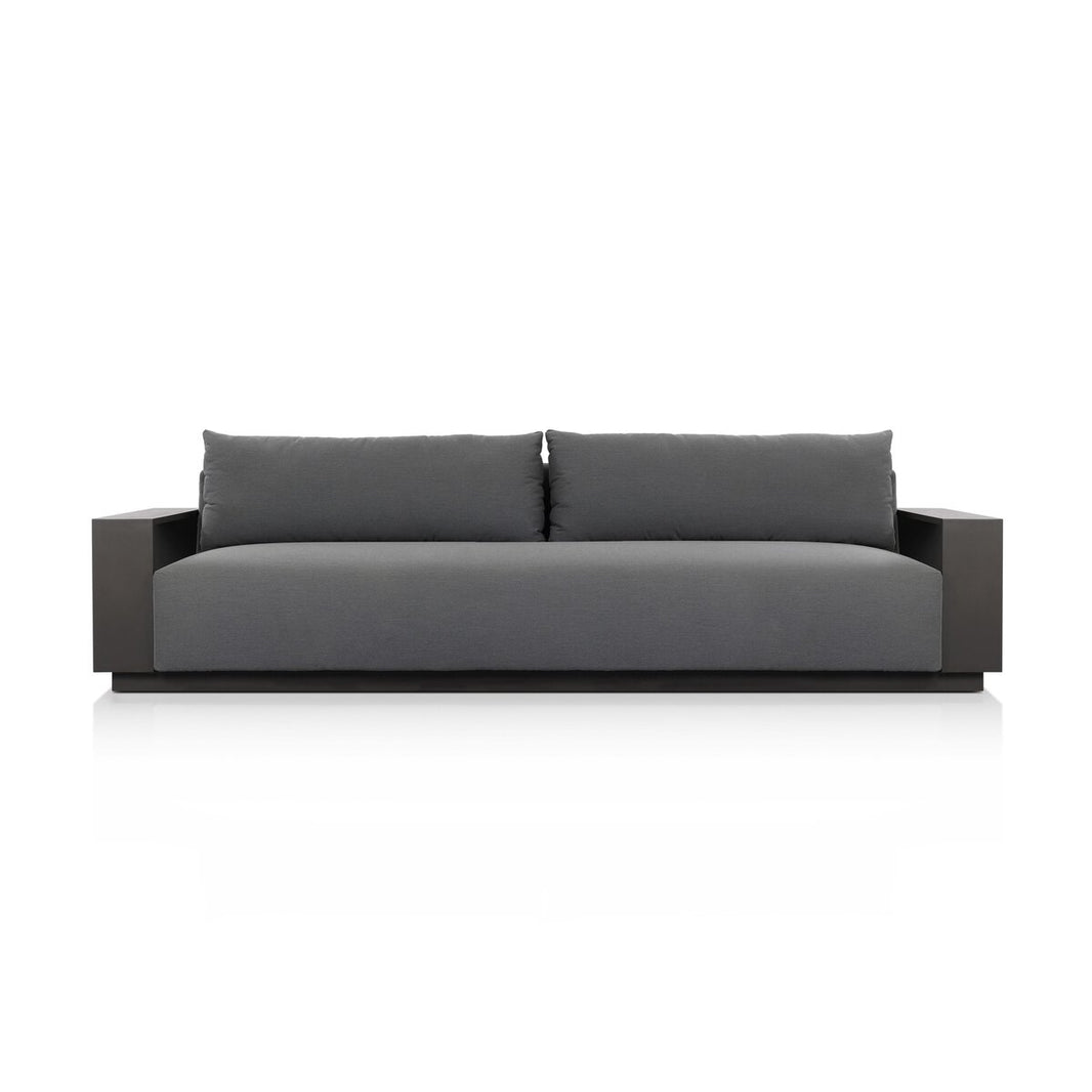 The Heavy Metal Framed Outdoor Sofa is a modern gray sofa with two large back cushions and wide, flat armrests. Set against a plain white background, its heavy metal framing adds durability for outdoor use.