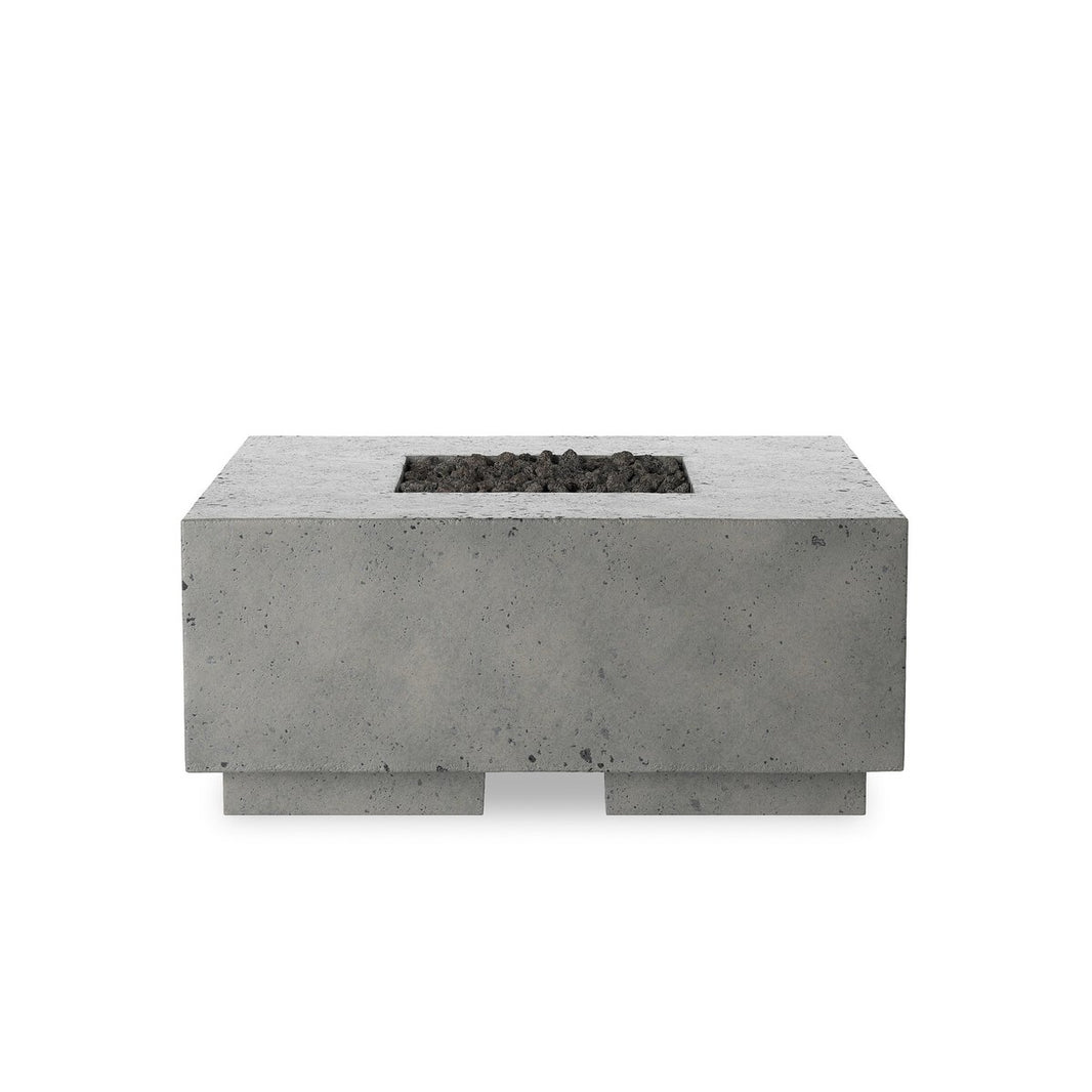 The Square Outdoor Fire Table is a rectangular, gray glass-reinforced concrete piece with a central square opening filled with dark stones, displayed against a plain white background.