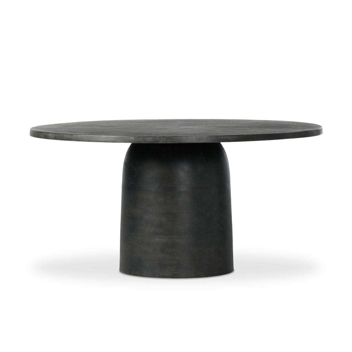 The Aged Aluminum Outdoor Dining Table features a round, grey, aged finish with a thick pedestal base and smooth surface, making it ideal for indoor or outdoor use. Shown against a plain white background.