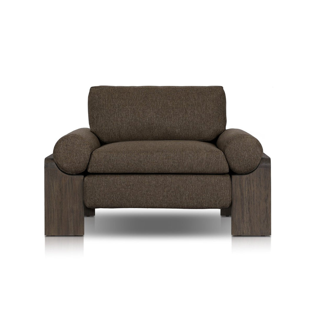The Wide Leg Outdoor Chair features thick, rounded armrests, sturdy block-style wooden legs, and dark brown textured upholstery, all set against a white background.