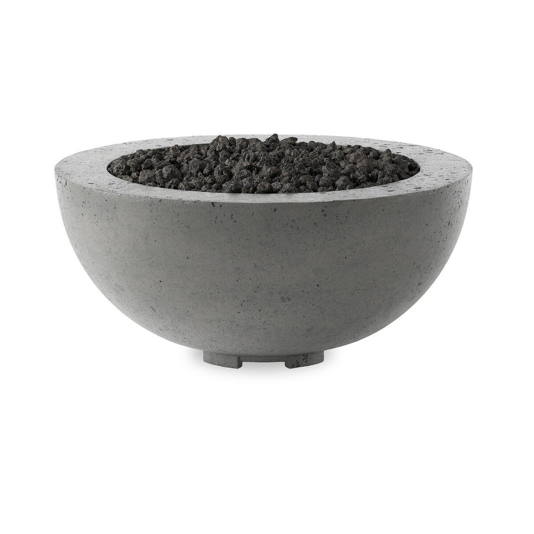 The Domed Outdoor Fire Table is a round, gray fire pit made of smooth glass-reinforced concrete with dark lava rocks and short, sturdy legs—an elegant natural gas centerpiece for any setting.