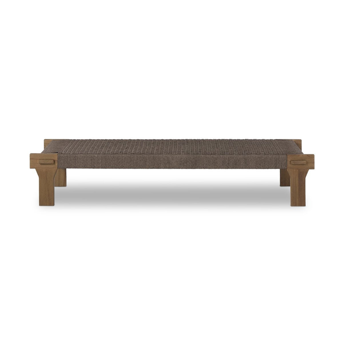 The Monochromatic Weaved Coffee Table features a woven brown seat and sturdy rectangular wooden legs inspired by Indonesian design, shown against a white background.
