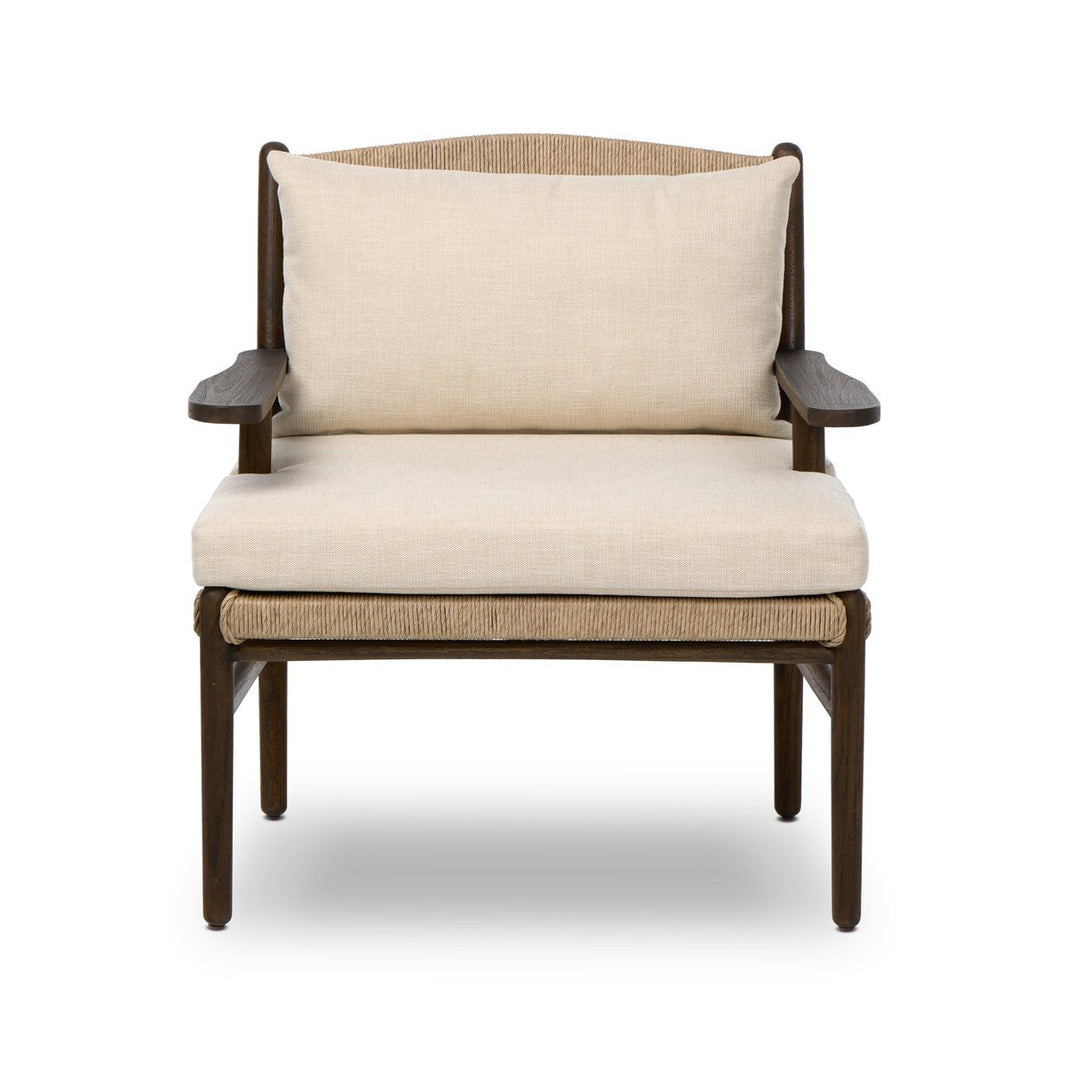 The Outdoor Shaker Chair features a modern design with a dark wood frame, light beige seat and back cushions, and armrests, shown against a white background.