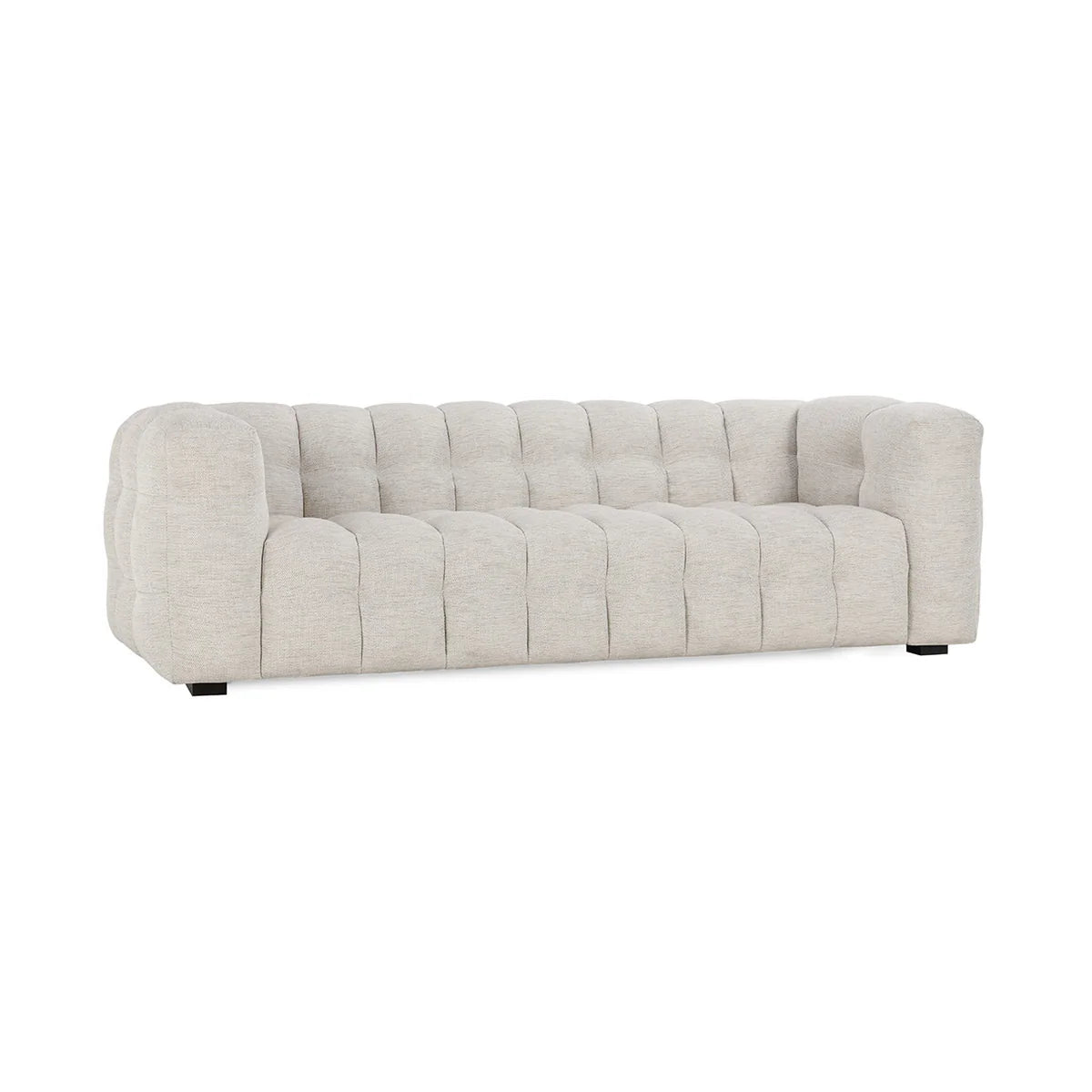 The Upholstered Sofa features a modern design with light beige tufted upholstery, deep cushions, rounded arms, a low backrest, and short black legs, presented against a white background.