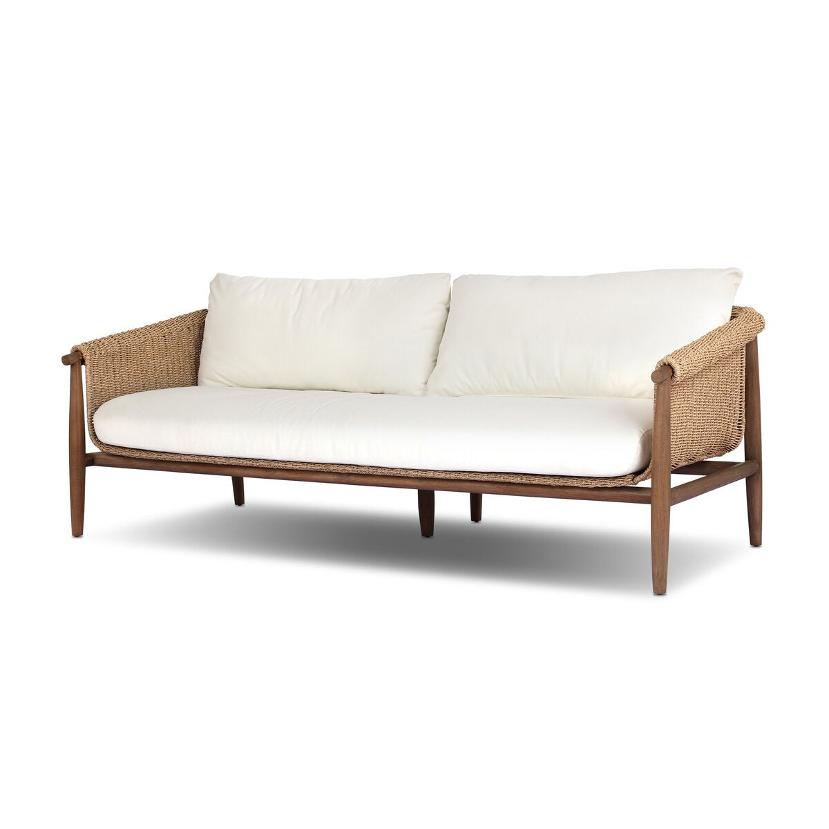 The Woven Outdoor Sofa features a wooden frame with woven faux hyacinth sides and back, white seat and back cushions, and clean lines for an elevated, airy look inspired by vintage design.