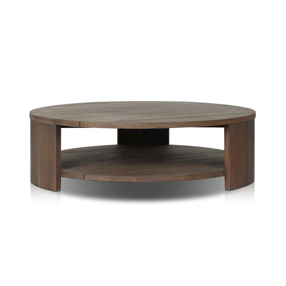 The Outdoor Chunky Round Coffee Table features a smooth, medium brown wood-finish top, an open modern design, a lower storage shelf, and stands on three chunky legs for style and stability.