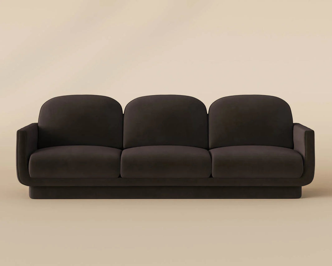 The Retro Sofa is a modern, dark brown three-seater with upholstered cushions and rounded backrests and armrests, shown against a plain beige background.
