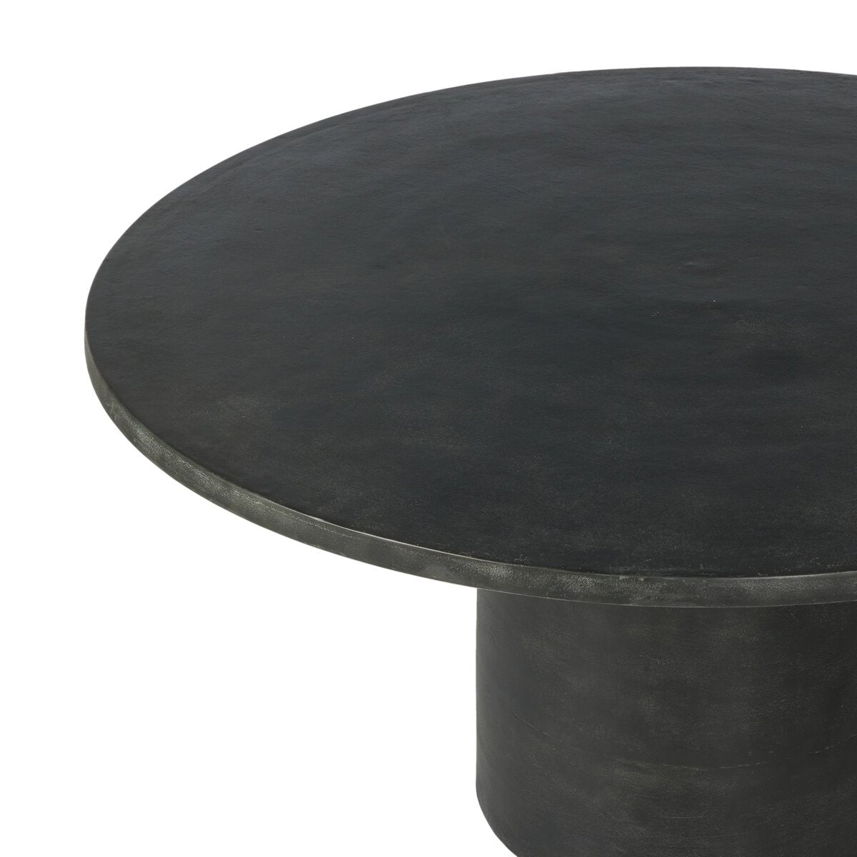 The Aged Aluminum Outdoor Dining Table features a round, black design with a smooth, flat surface and thick pedestal base, ideal for indoor or outdoor use. Shown from an angled top view against a white background.