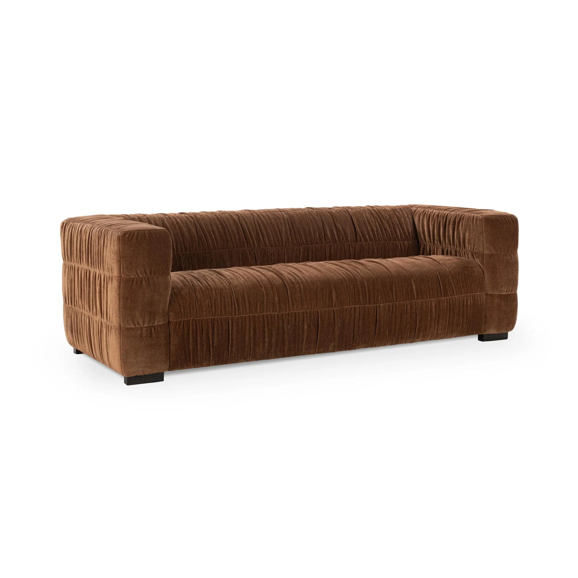 The Ruched Upholstered Sofa features luxury brown upholstery, deep tufting, square arms, a low boxy design, and short black legs—a modern and elegant statement piece.