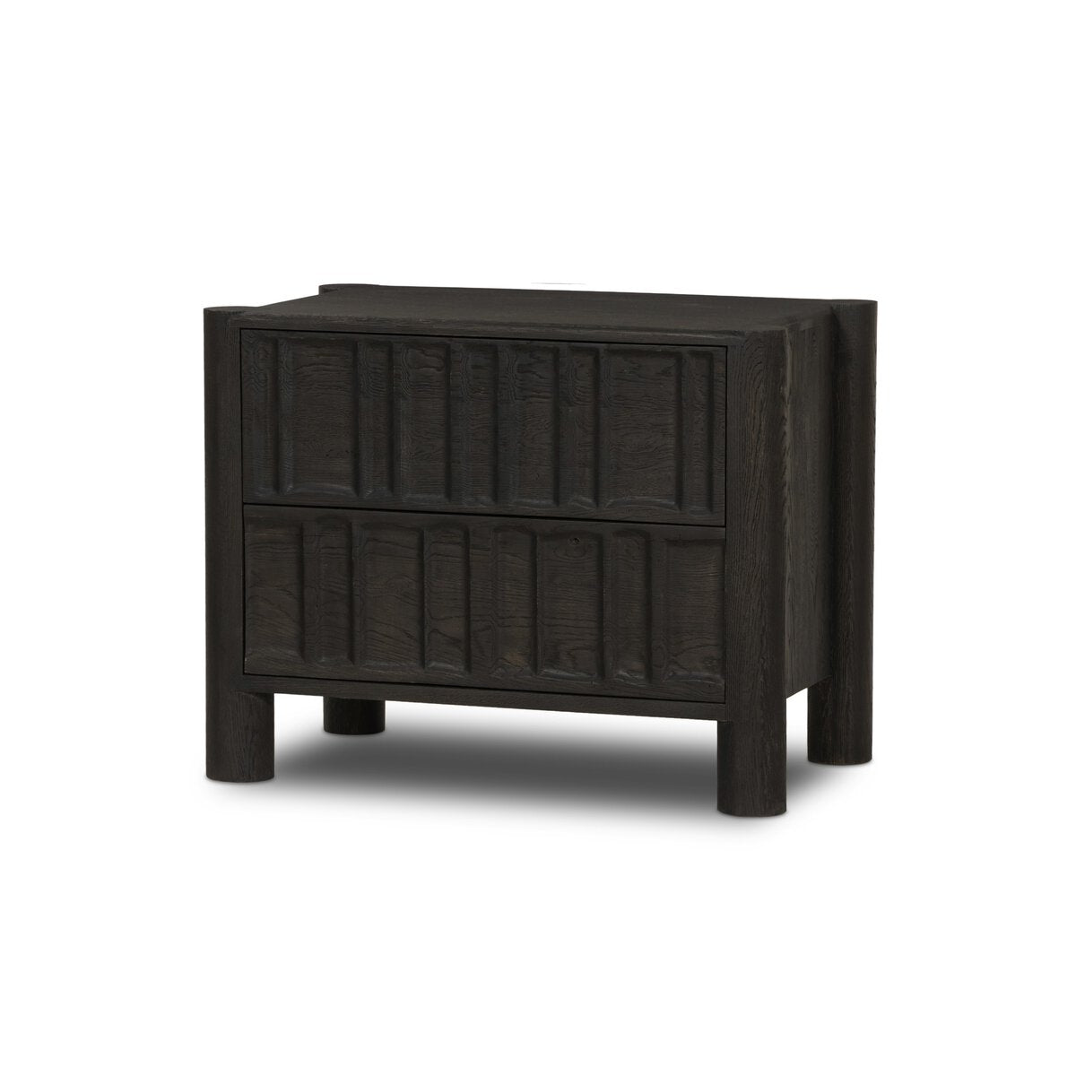 The Primitive Nightstand is a modern, dark wood piece made from cocoa-finished oak, featuring two drawers with vertical rectangular patterns and sturdy cylinder legs, displayed against a plain white background.