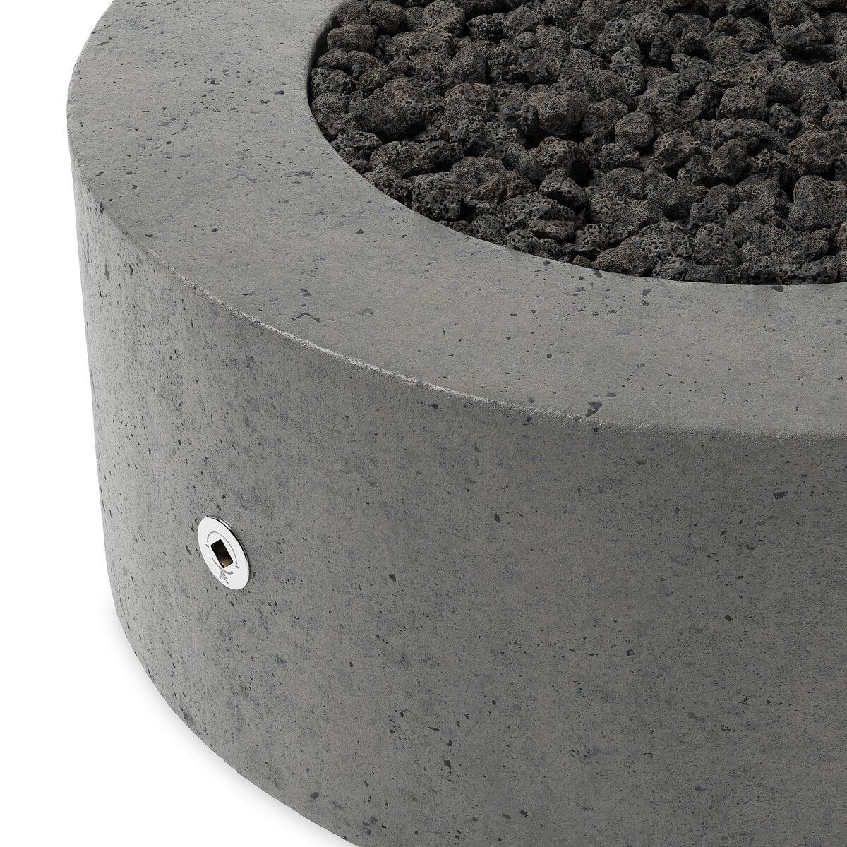 Close-up of the Round Outdoor Fire Table, featuring gray glass-reinforced concrete and filled with black lava rocks. A small metal access hole is visible on the side of this natural gas fire pit.