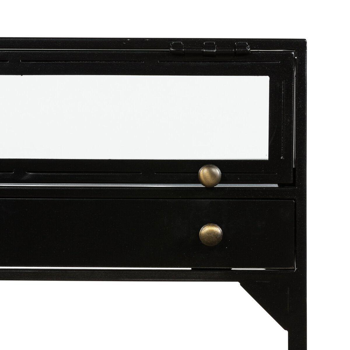 A close-up of the Shadowbox End Table, featuring a matte-black metal frame, a rectangular glass top, and a lower drawer with two round brass knobs.
