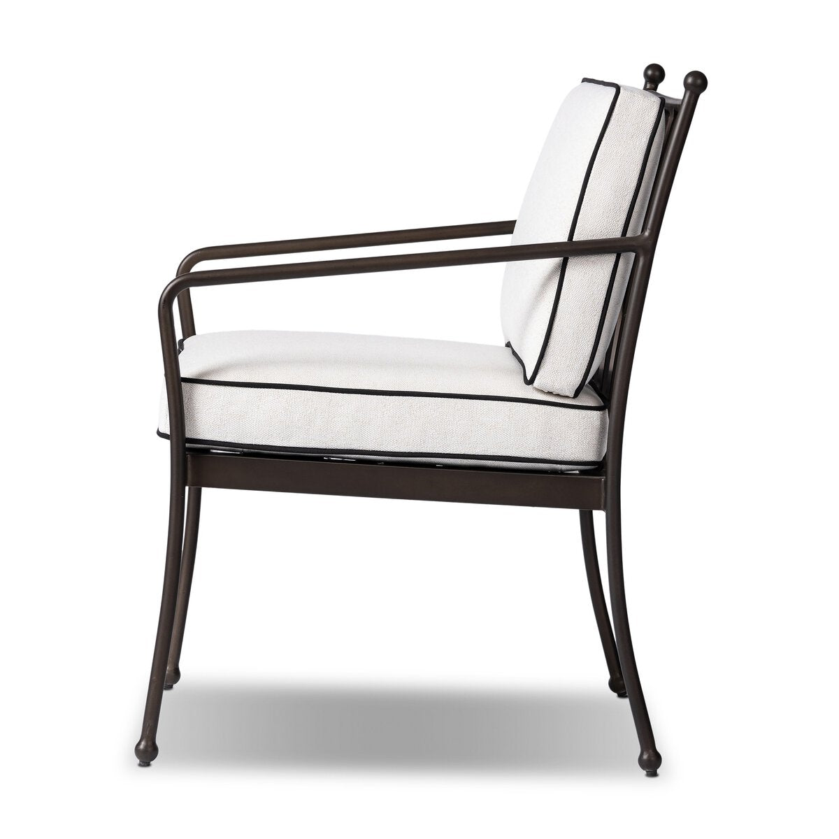 Side view of the Tally Outdoor Chair, 34.50"d x 28.00"w x 35.50"h, featuring a slim black metal frame, armrests, slightly curved legs, and a light-colored cushioned seat and backrest with black piping on the upholstery.