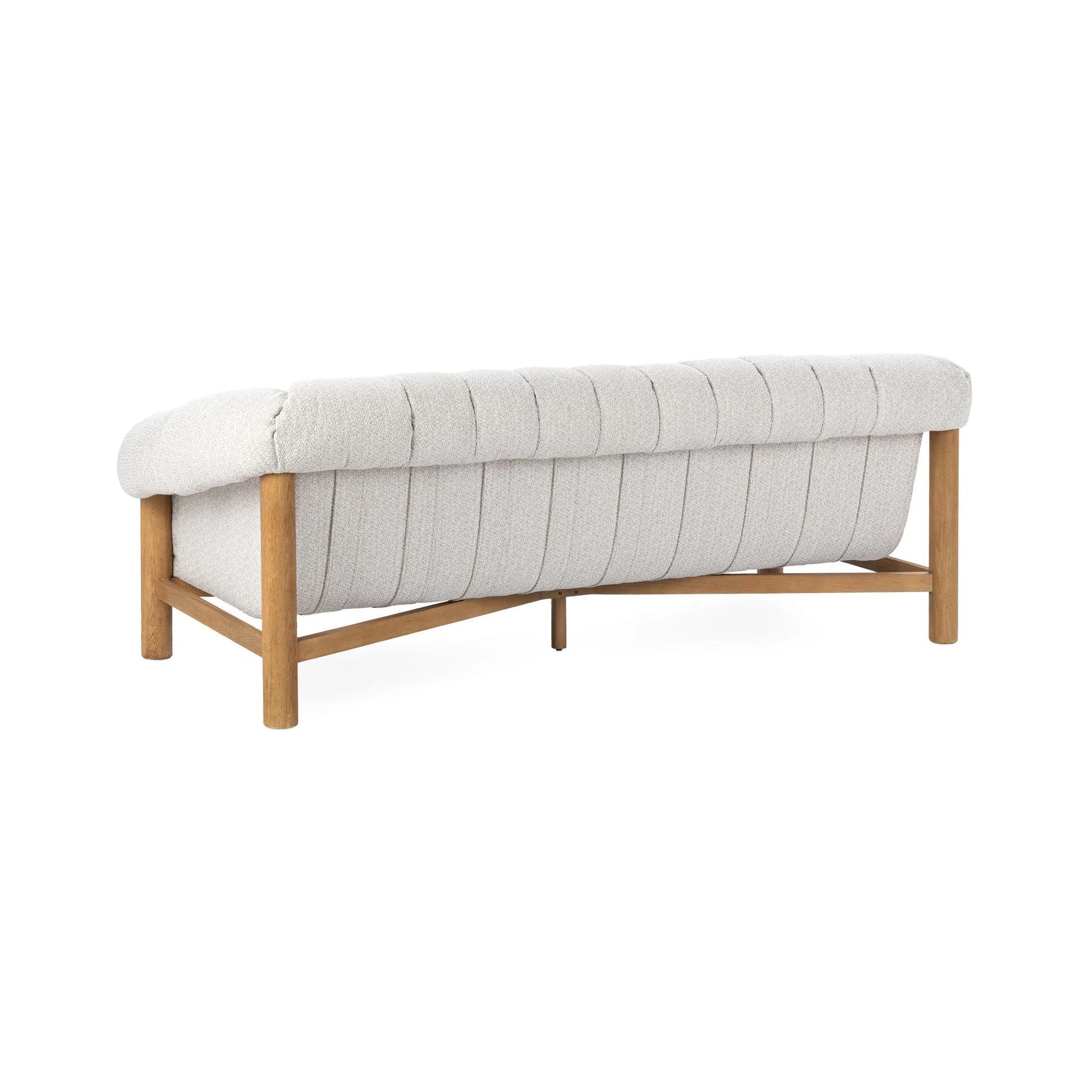 The Plush Upholstered Sofa features light gray polyester cushions, vertical tufting, and a brushed oak wood frame, displayed from the back at an angle.
