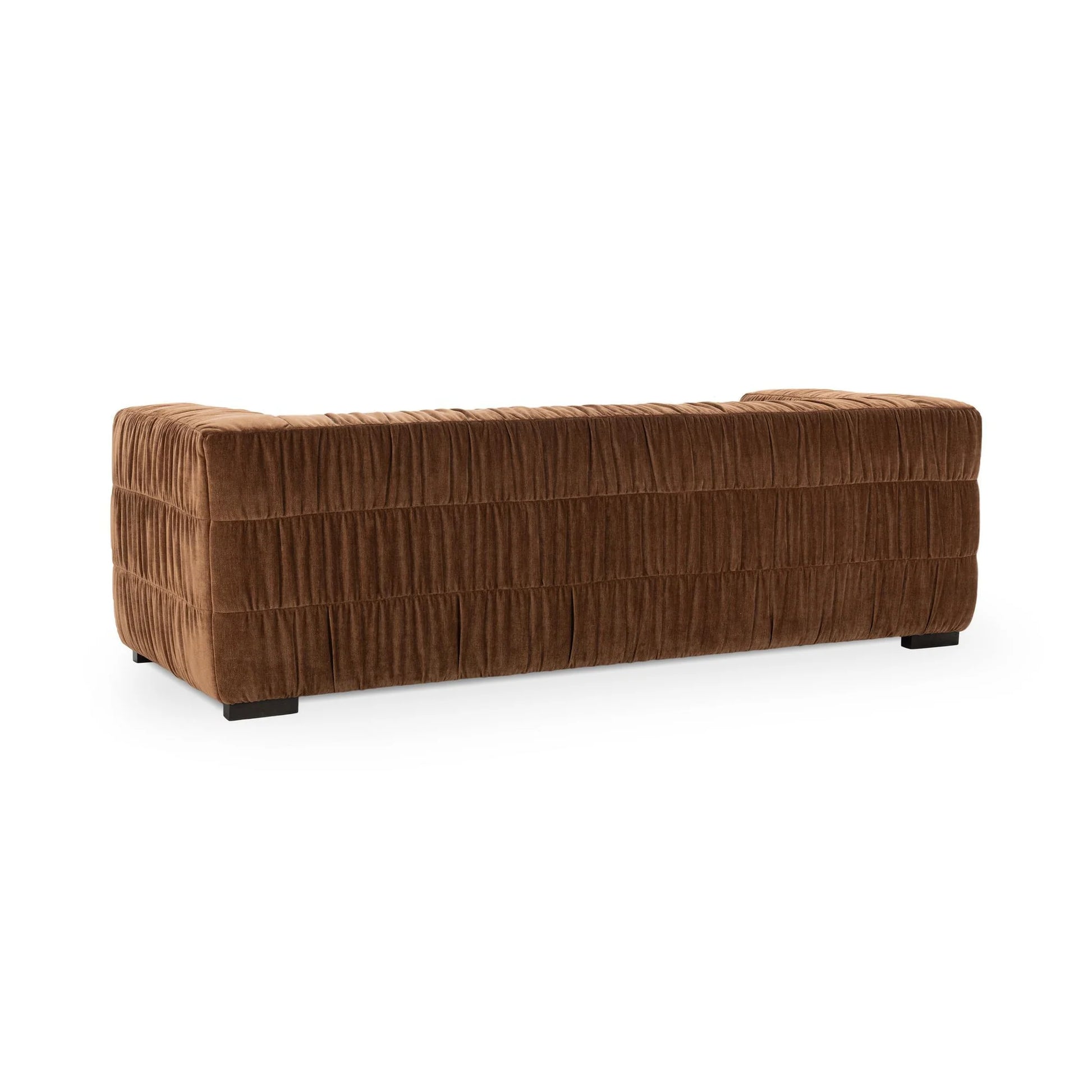 The Ruched Upholstered Sofa is a plush, rectangular brown piece with a soft corduroy-like texture and block feet, highlighting luxury and modern artistry, shown from the back against a plain white background.