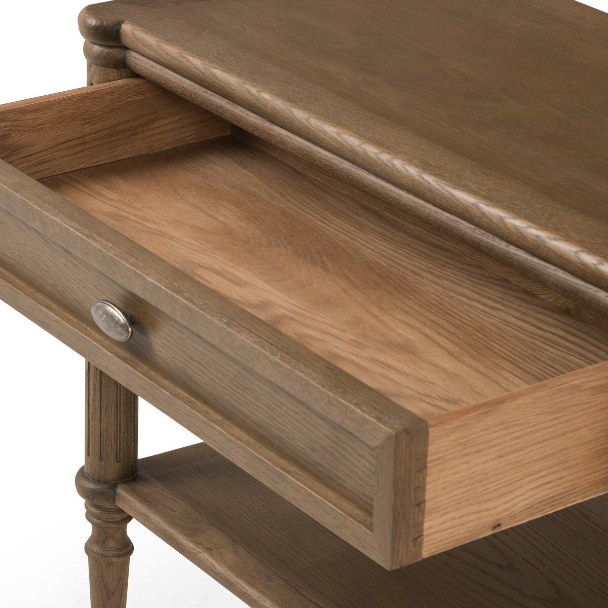 A close-up of the European Nightstand with an open drawer displays its wood grain texture, turned legs, lower shelf, and a round metal knob.