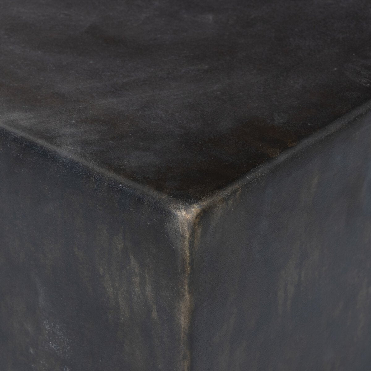 Close-up of the corner of the Arched Base outdoor Coffee Table2, a dark, matte-finish cast aluminum piece with textured surface and subtle color variations.