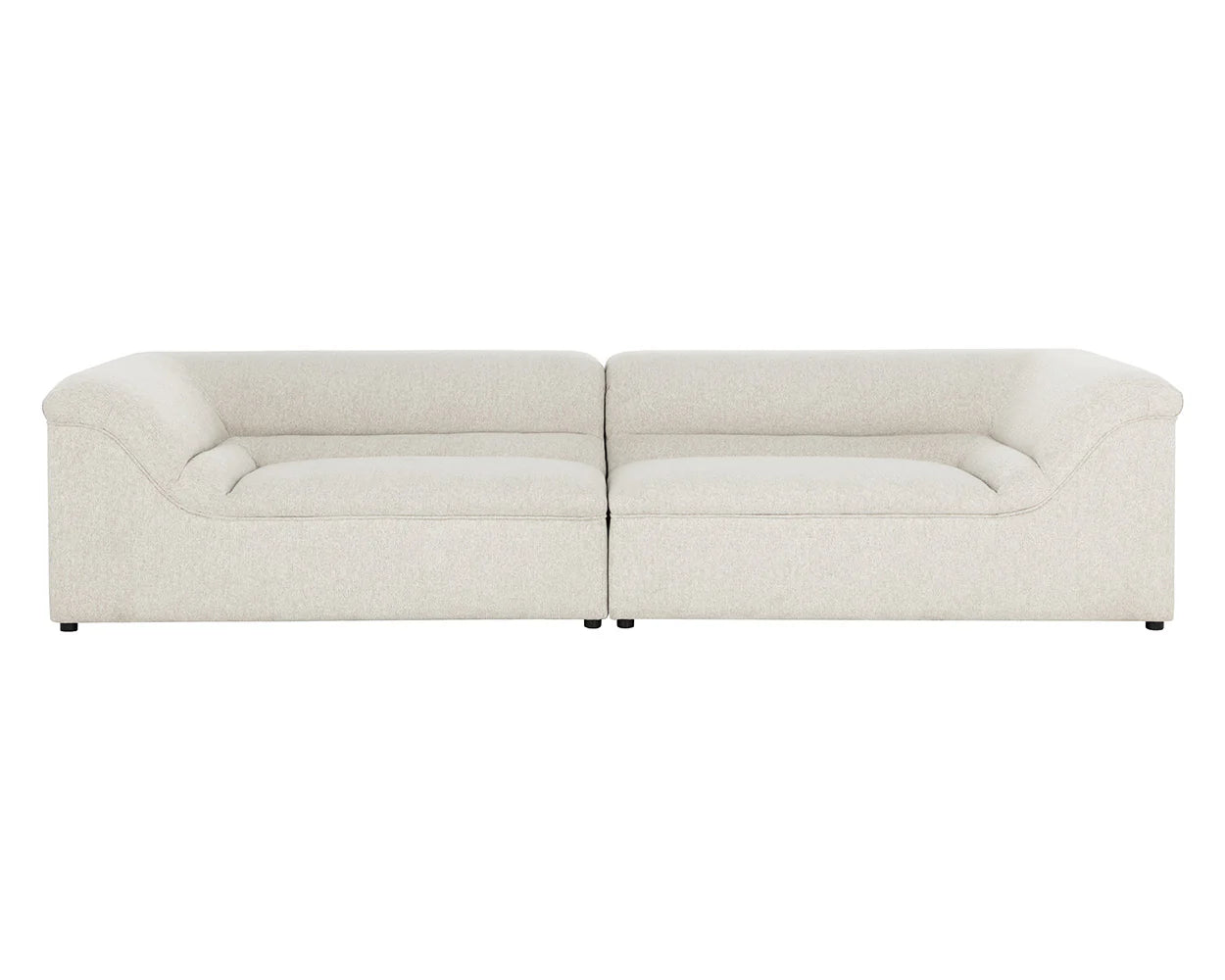 The Curved Upholstered Sofa is a modern, low-profile piece in light beige with two connected sections, plush seats, and gently curved armrests. Its minimalist design and fabric upholstery create a sleek, contemporary look.